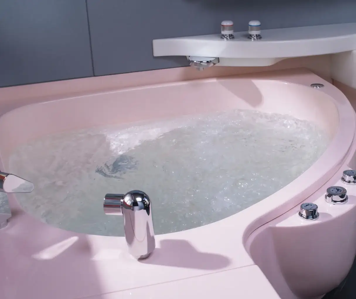Dettaglio della vasca rosa del bagno Adria con rubinetteria cromata, Matsushita Electric Works