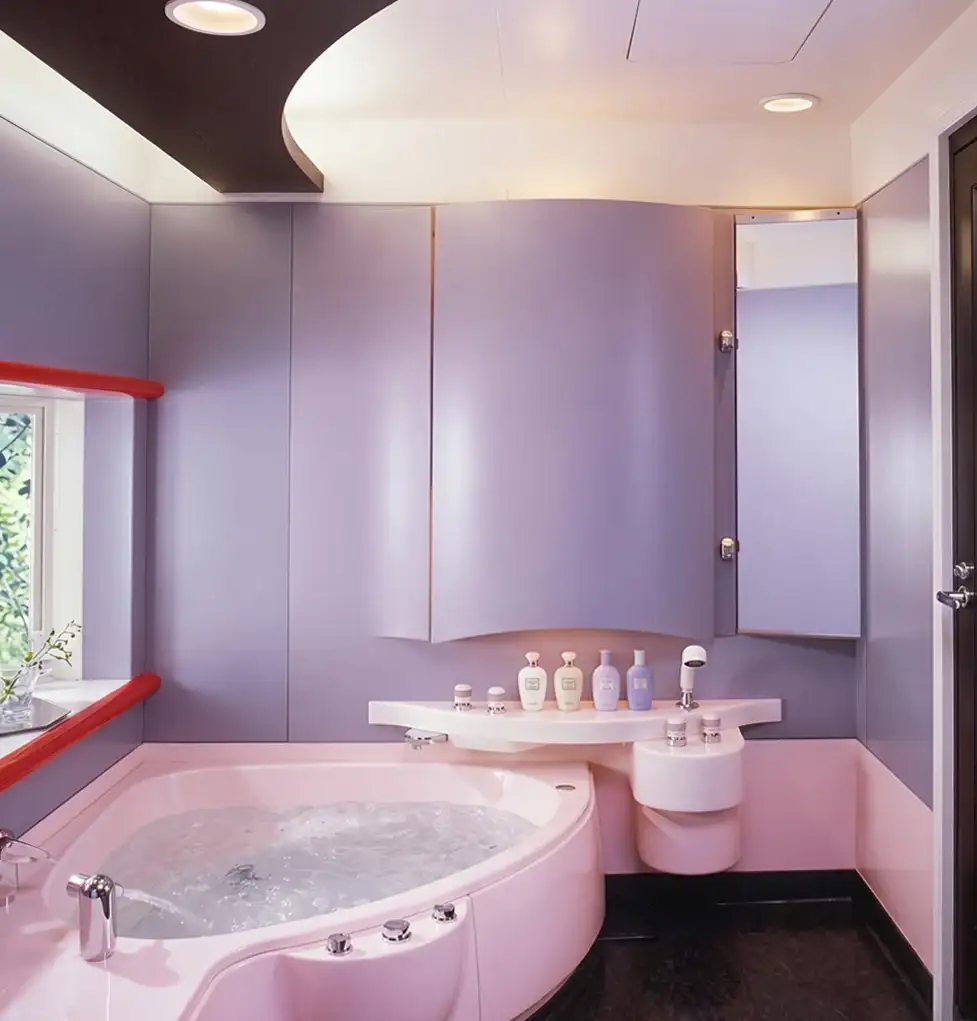 Bagno Adria con vasca ad angolo rosa, pareti lilla e mobile curvo, Matsushita Electric Works