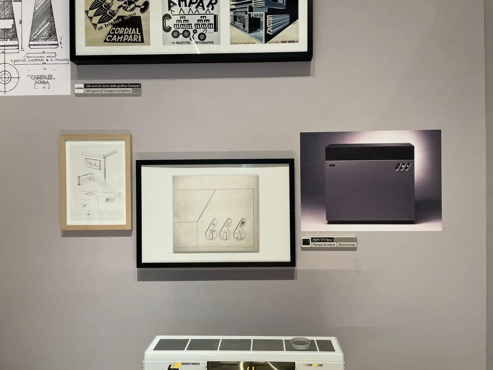 Parete del Museo Compasso d’Oro ADI di Milano con la stampa fotografica di AGH 171 New, uno schizzo e un disegno dei comandi incorniciati
