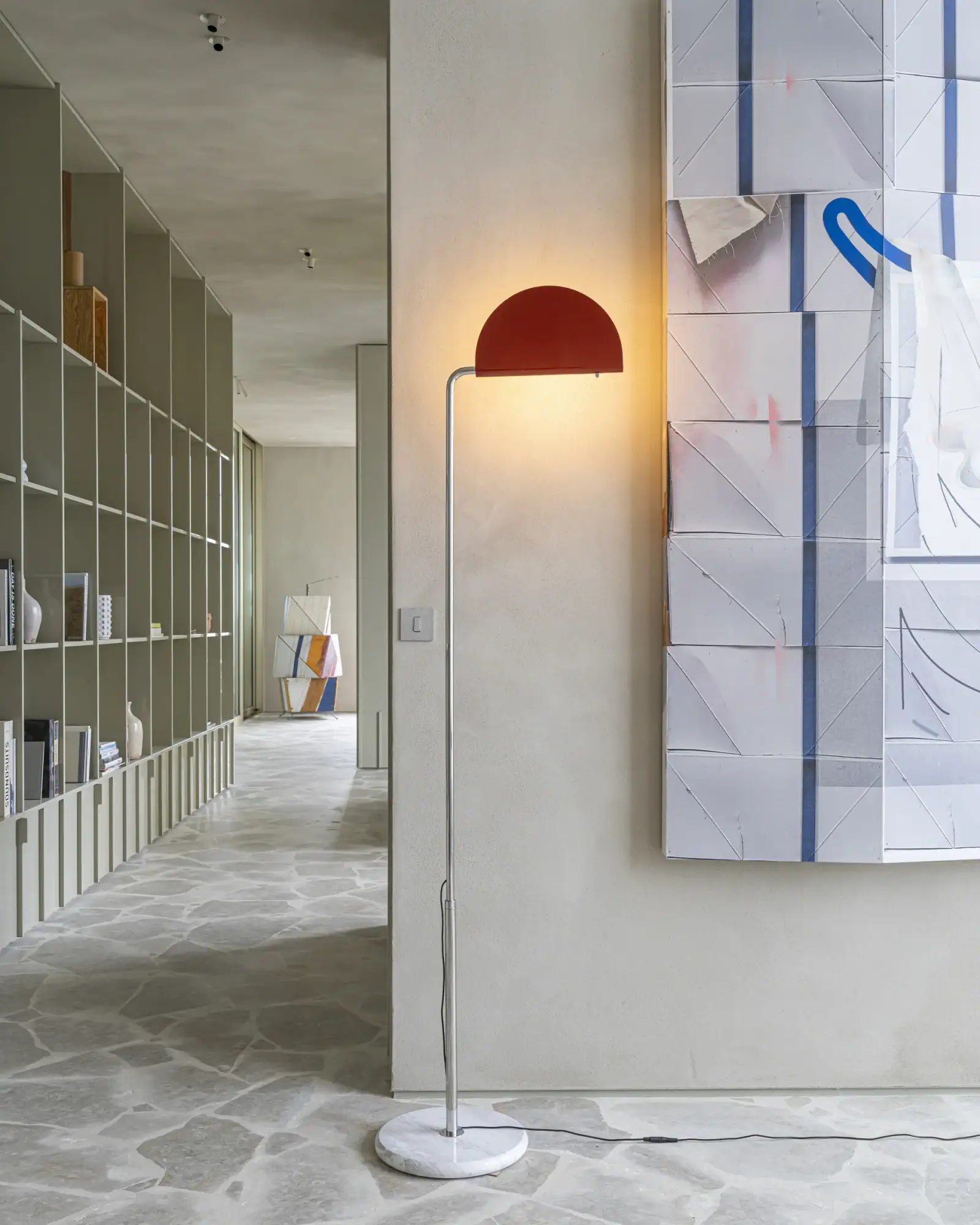 Mezzaluna rossa accesa in un corridoio con libreria e pavimento in pietra, DCW éditions