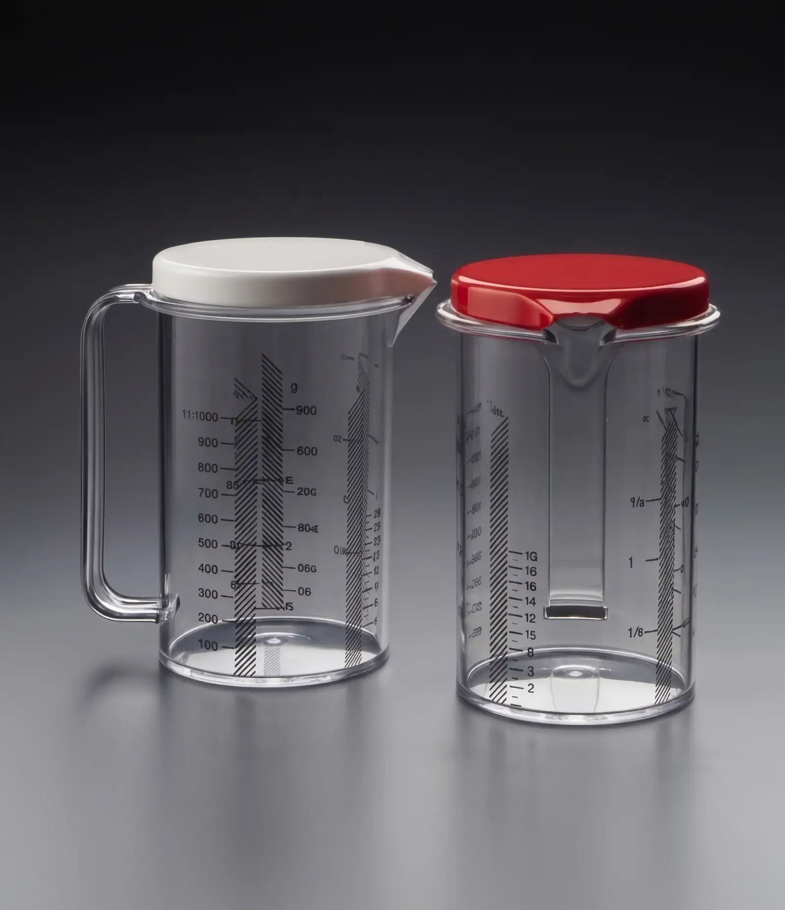 Due caraffe graduate trasparenti con coperchio bianco e rosso, Fratelli Guzzini
