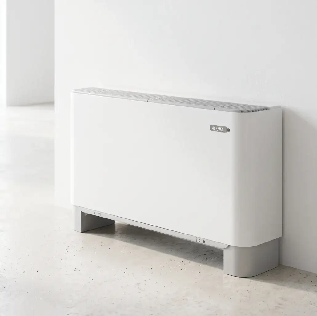 Ventilconvettore FCX bianco a pavimento contro una parete chiara, Aermec