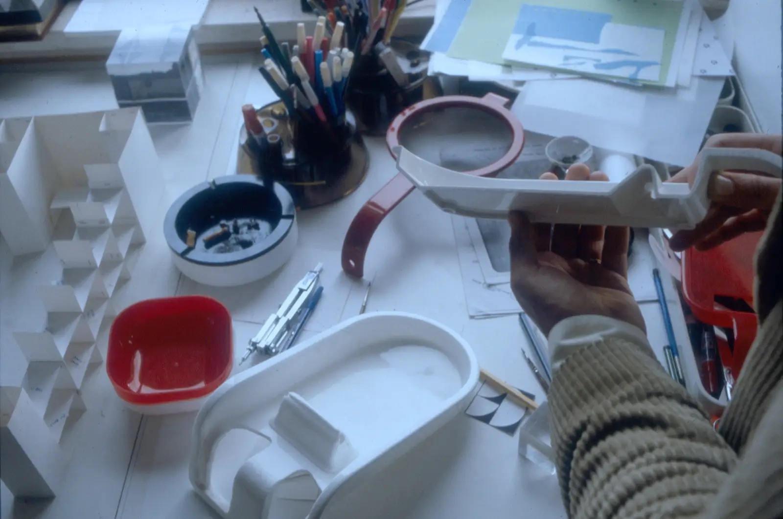 Primi prototipi stampati in plastica dell’impugnatura sul tavolo da disegno dello studio, con matite e strumenti