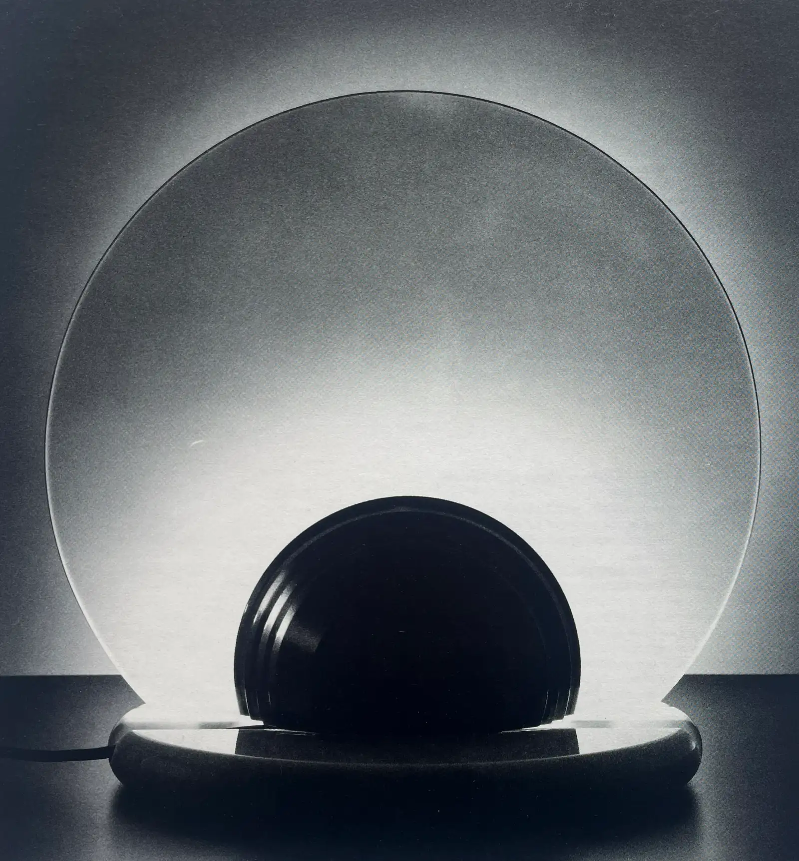Lampada da tavolo Gong con disco in vetro e semisfera nera; foto in bianco e nero, Skipper