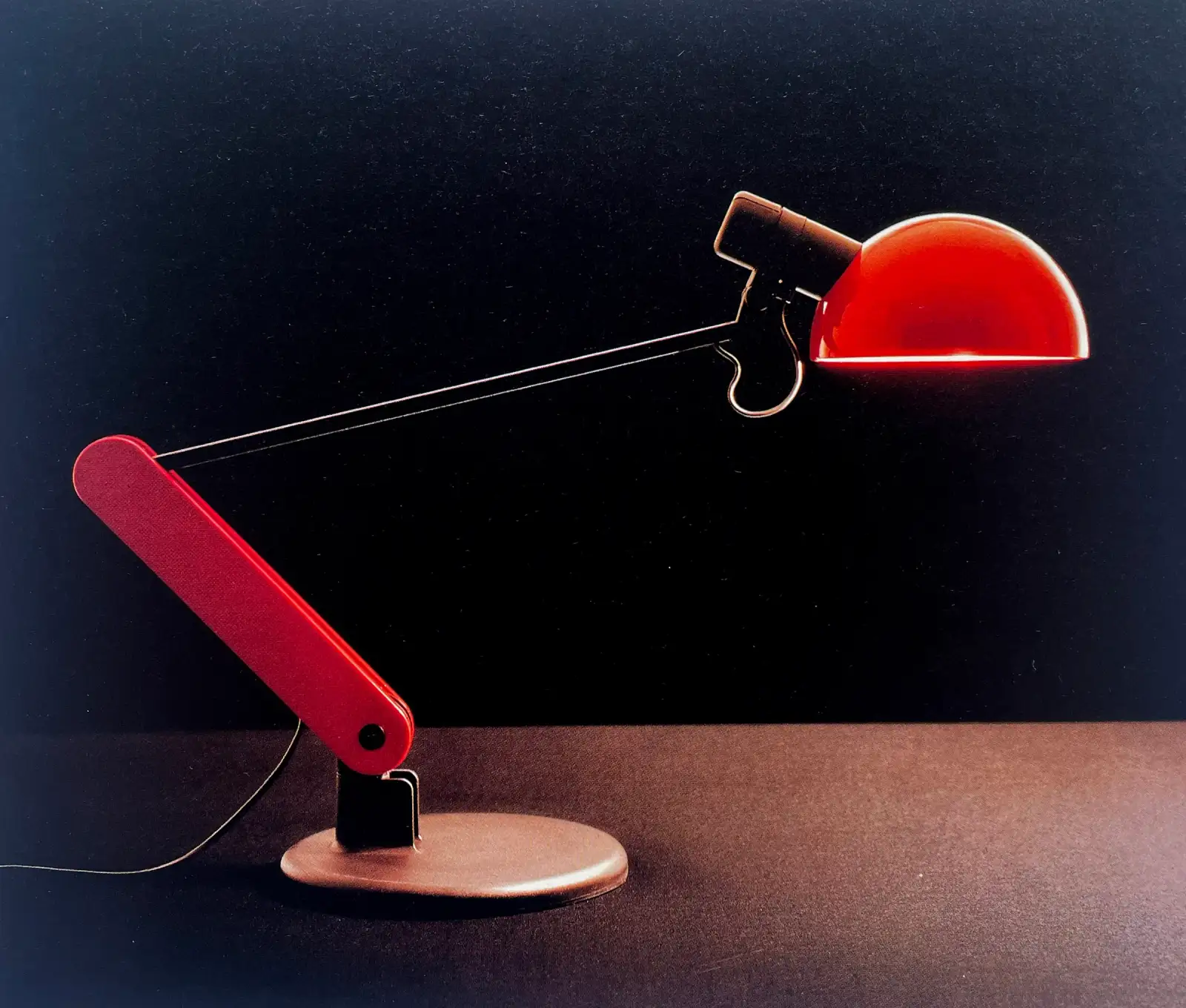 Lampada da tavolo Praxis rossa con braccio snodato e riflettore a semicerchio, iGuzzini illuminazione